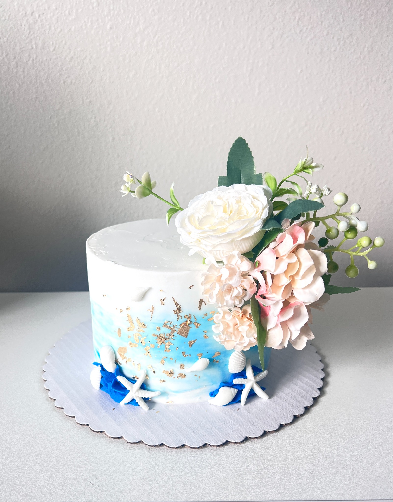 Beach themed floral cake with shells and gold leaf