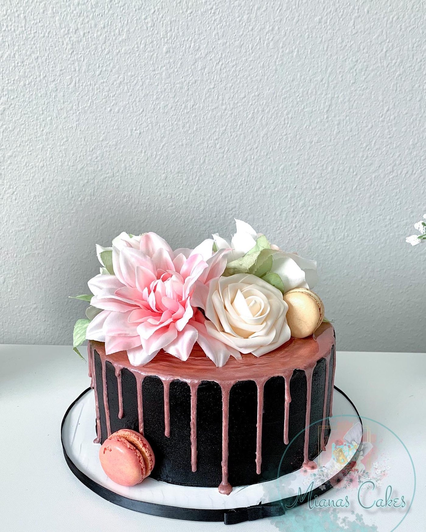 Black custom cake with rose gold drip and flowers