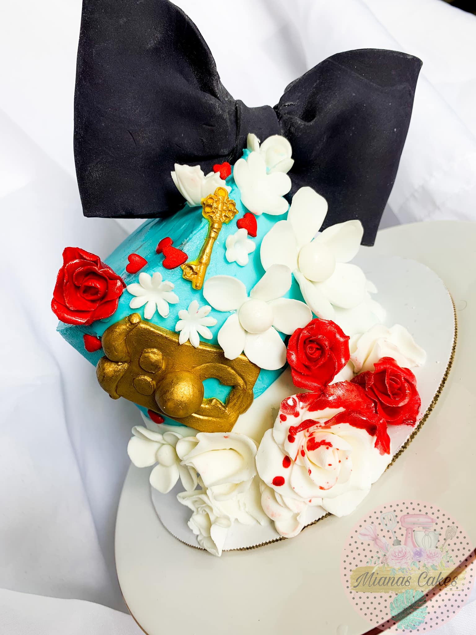 Blue bow themed cake with flowers and gold details