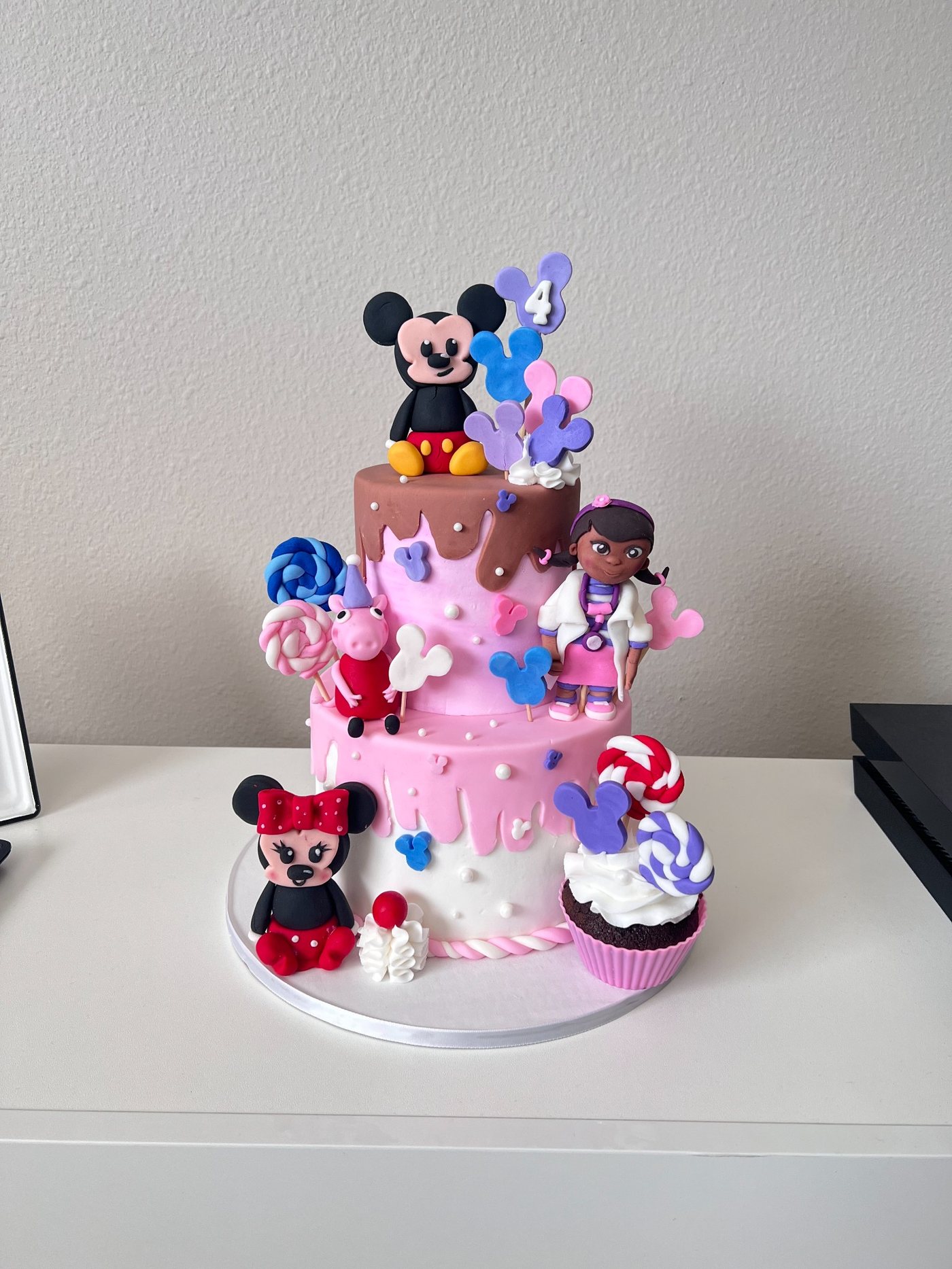 Pink character themed tiered cake
