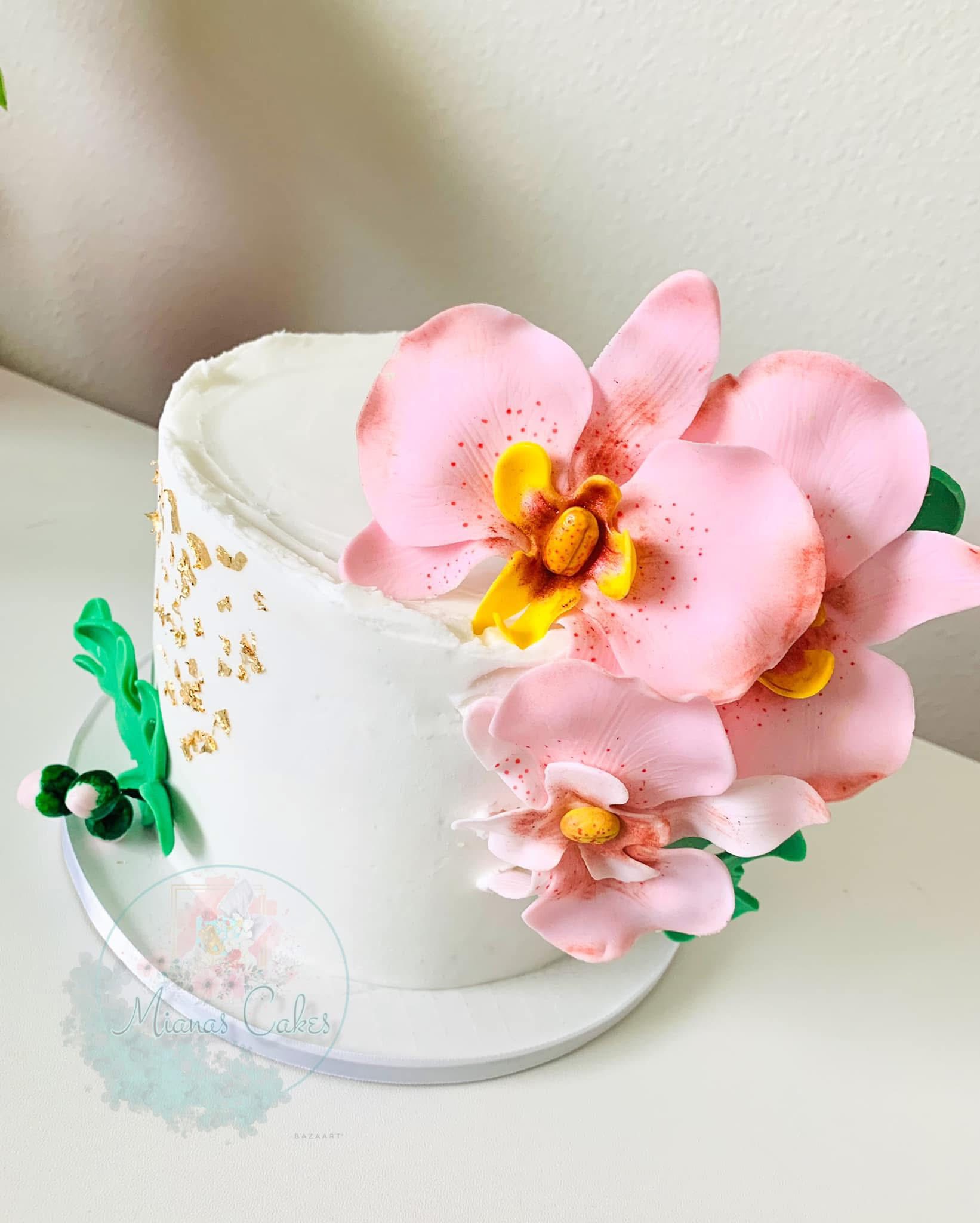 White cake with pink orchid flowers