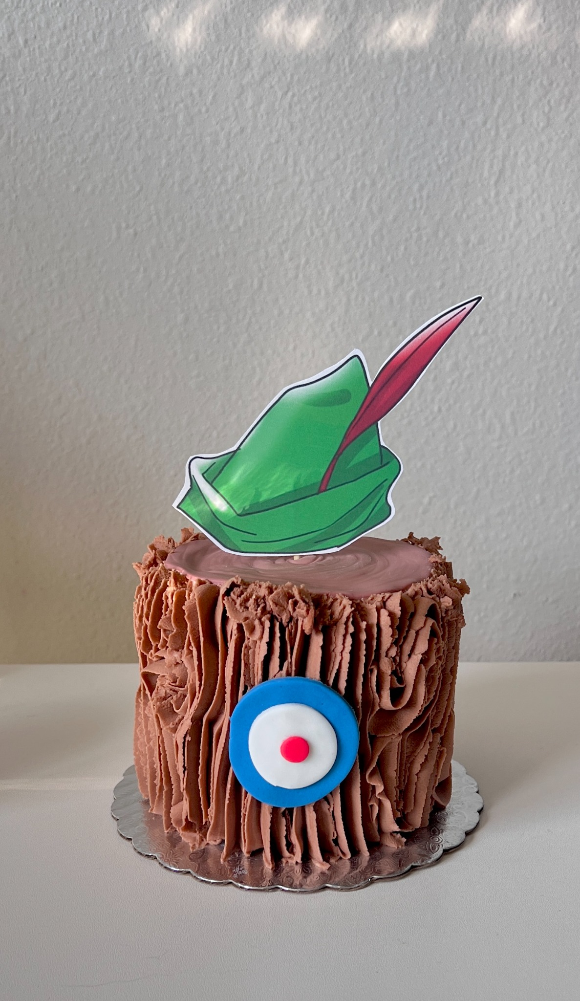 Storybook themed brown textured cake with green hat topper